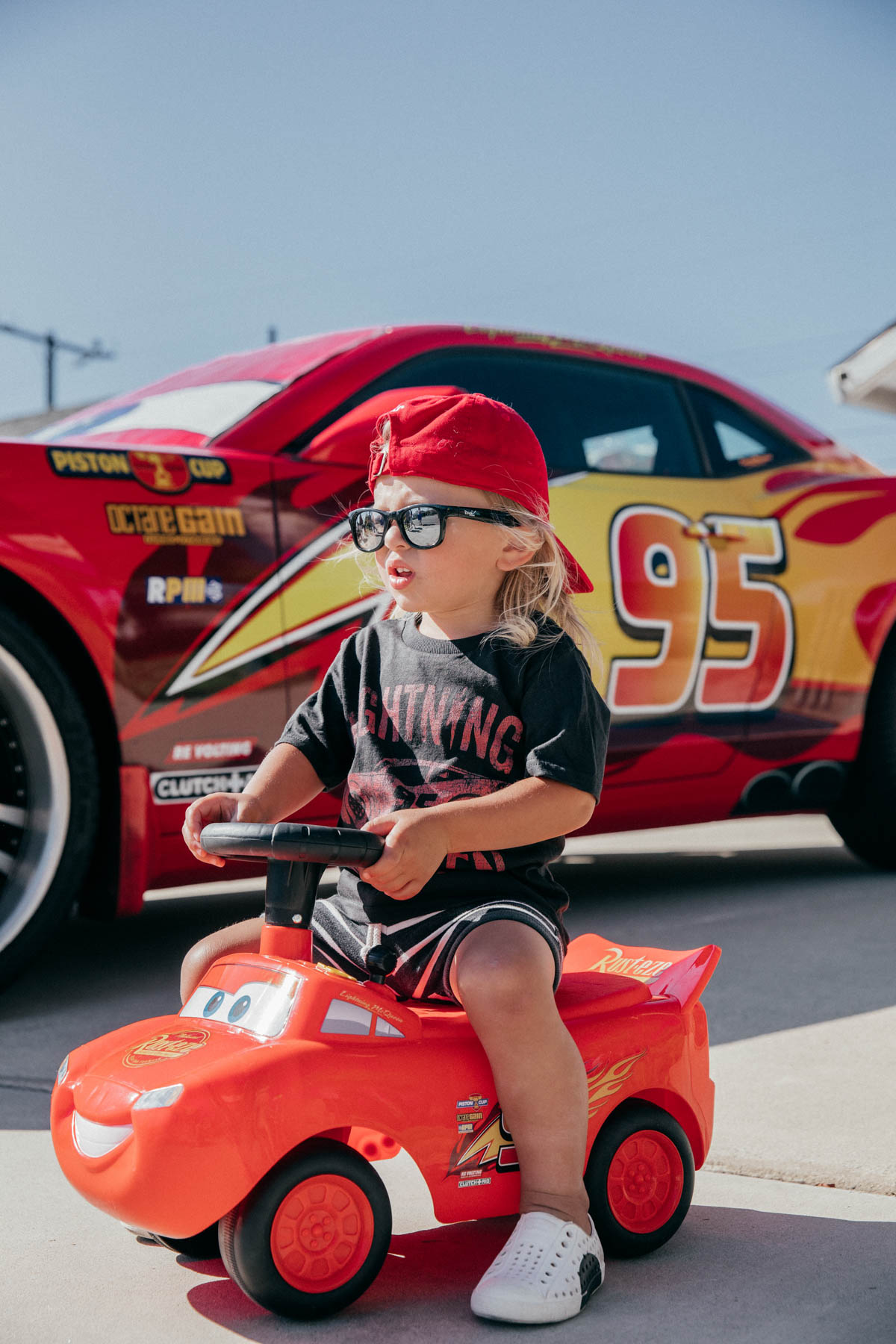 Toddler using Ride On Lightning McQueen Car Toy at Disney Pixar Cars themed birthday