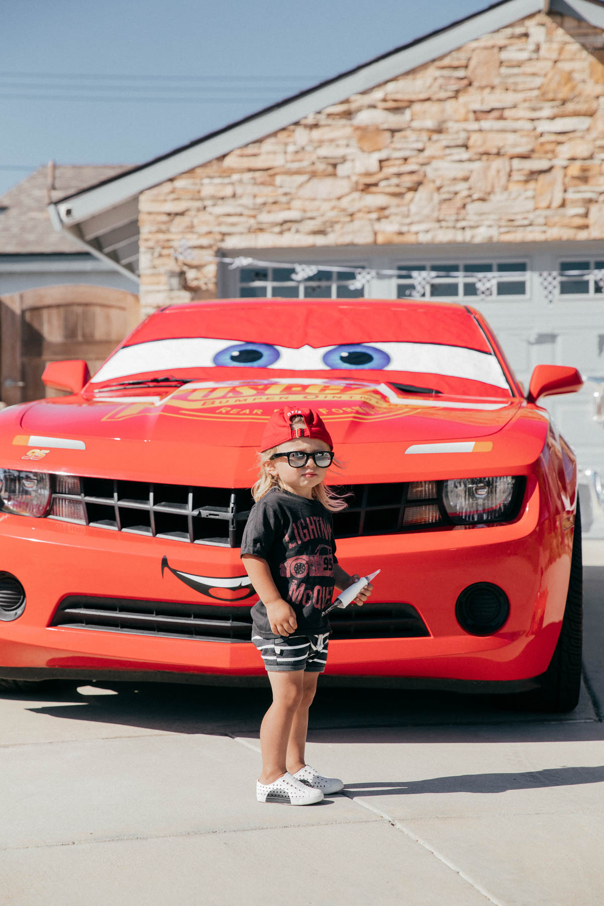 Happy Toddler posing with Lightning McQueen Impersonator Car at Disney Pixar Cars themed birthday