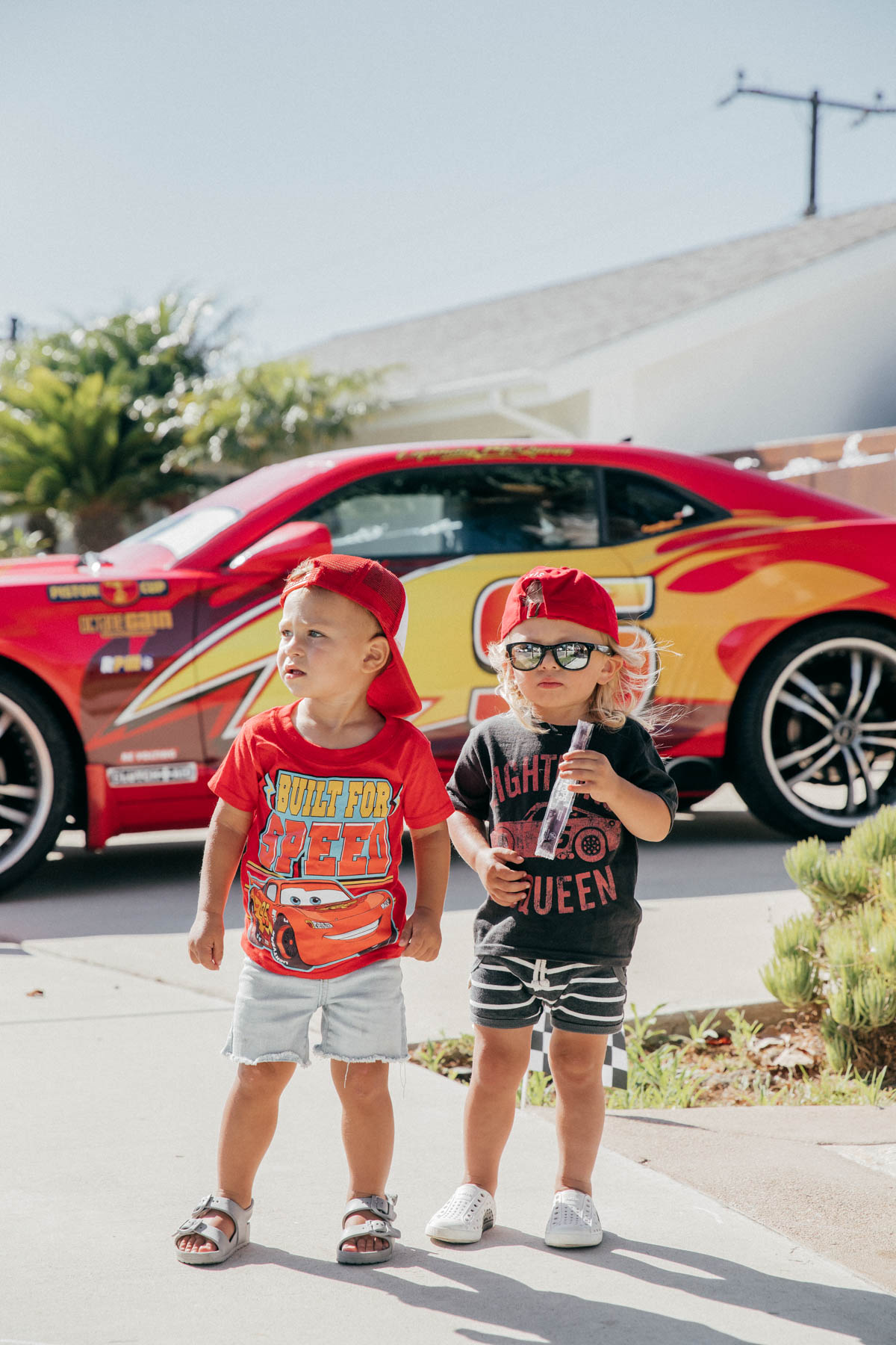 Happy Toddler Fridays posing with Lightning McQueen Impersonator Car at Disney Pixar Cars themed birthday