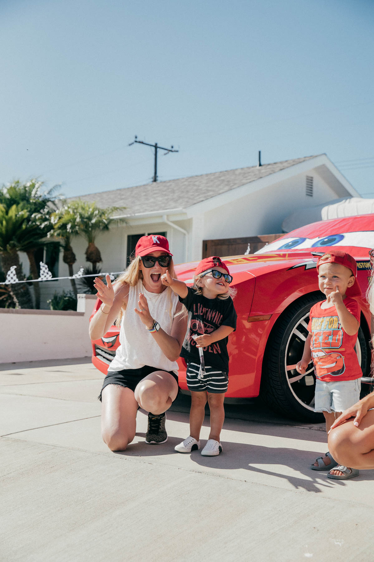 Mom and toddlers posing with Lightning McQueen Impersonator Car at Disney Pixar Cars themed birthday