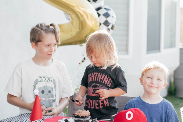 Family Singing Happy Birthday with Cupcake and race car theme decorations at Disney Pixar Cars themed birthday