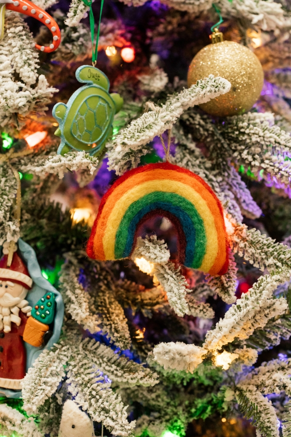 Indoor Holiday decor of lit Christmas tree and felt rainbow ornament