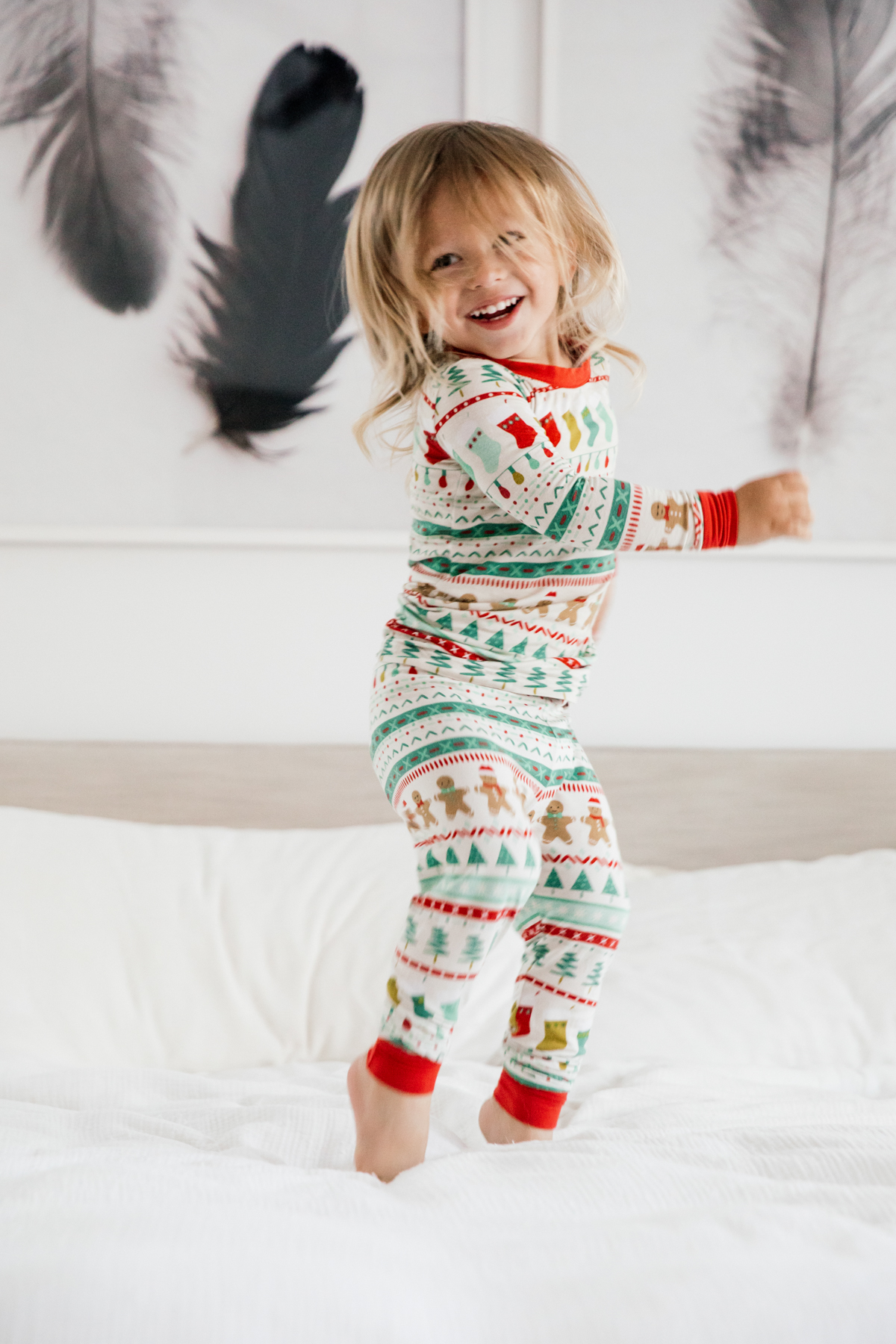Toddler in Holiday pajamas jumping on the bed